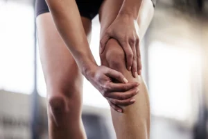 Person holding their knee in pain